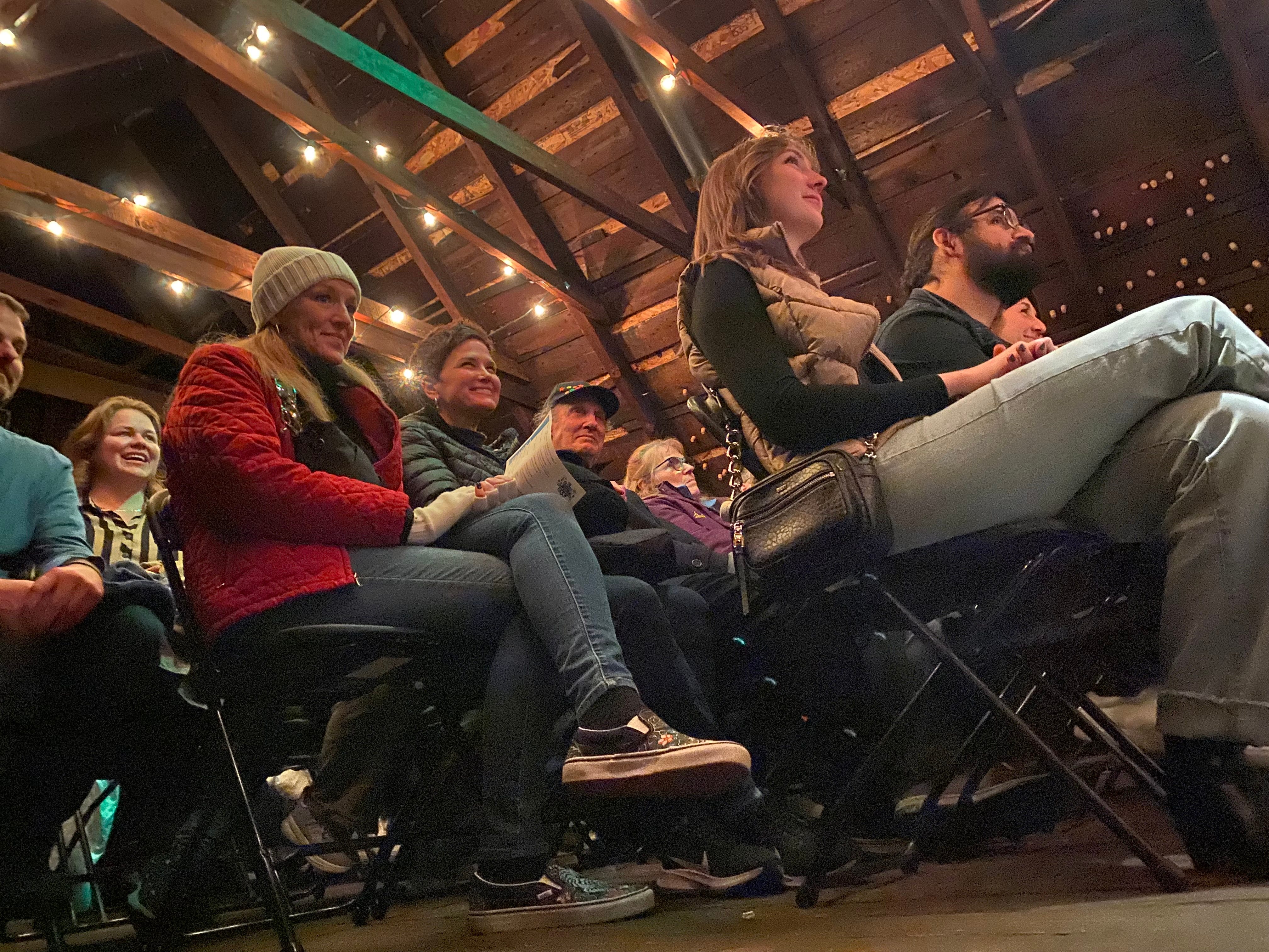 Engaged audience watching performance with string lights